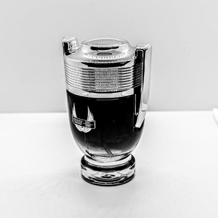 Frasco de perfume prateado sobre fundo branco